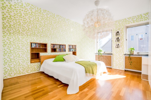 Inbyggda hyllor i sovrum med skir tapet med gröna blad